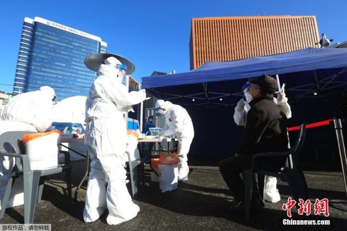 資料圖：韓國(guó)首爾，醫(yī)務(wù)人員對(duì)市民進(jìn)行新冠病毒檢測(cè)。