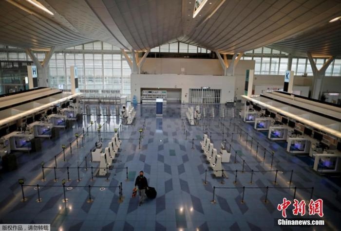 資料圖：日本東京，東京國(guó)際機(jī)場(chǎng)，一名乘客在國(guó)際航班航站樓的登機(jī)區(qū)。