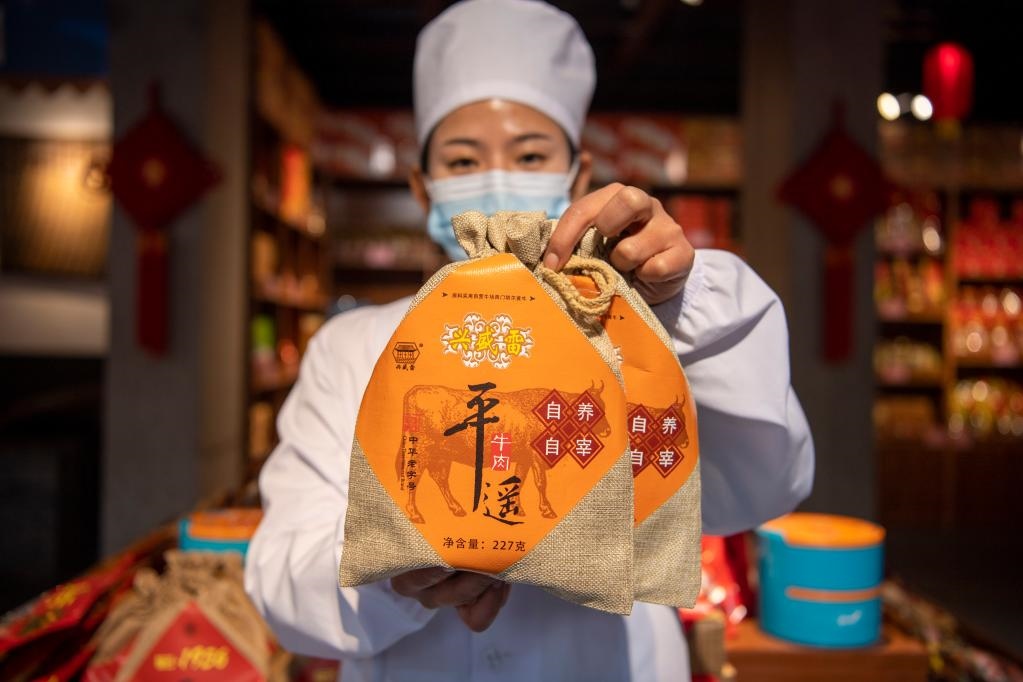 1月27日，在平遙古城南大街的一家平遙牛肉店內(nèi)，工作人員展示一款牛肉產(chǎn)品。新華社記者 楊晨光 攝