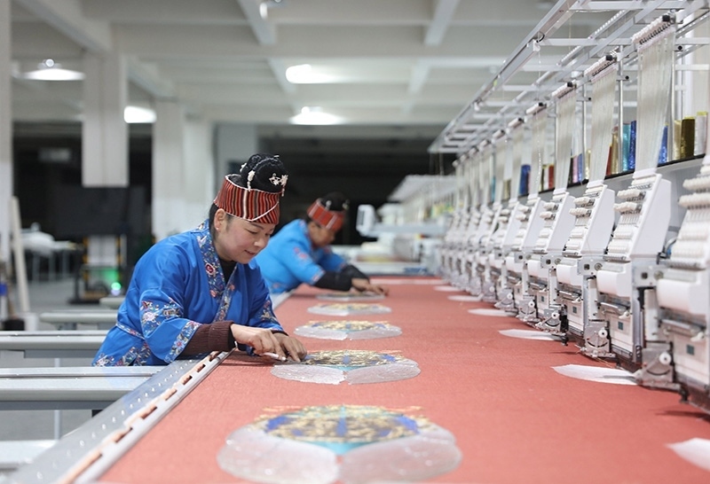 2023年2月13日，貴州省黔東南苗族侗族自治州施秉縣工業(yè)園區(qū)，工人在機(jī)繡車間作業(yè)。