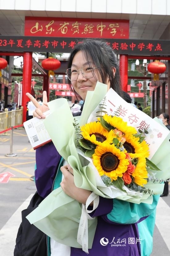 6月7日高考首日，山東67萬考生走進(jìn)考場，拼搏逐夢。在山東省實(shí)驗(yàn)中學(xué)考點(diǎn)，考生進(jìn)考場前手捧向日葵花拍照留念，寓意“一舉奪魁”。人民網(wǎng)記者 劉祺攝