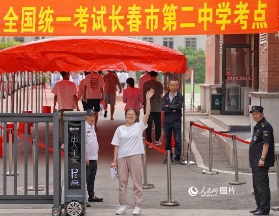 6月7日，在長春市第二中學(xué)考點(diǎn)，一名考生信心滿滿進(jìn)入考場，并與家長揮手致意。人民網(wǎng)記者 李洋攝
