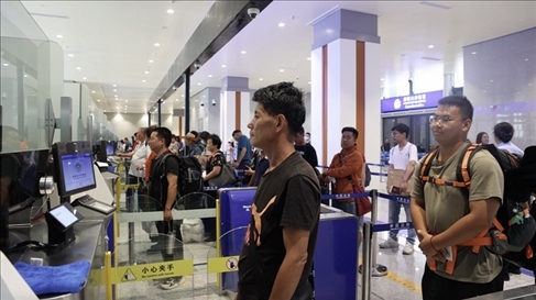 6月13日，乘坐中老鐵路國際旅客列車的旅客在磨憨邊檢大廳排隊候檢。李揚 攝