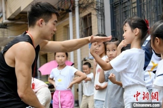 圖為大學(xué)生志愿者在組織孩子們參加體育健身活動(dòng)。廖光福 攝