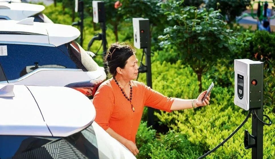 2023年5月24日，山東省膠州市新立街小區(qū)內(nèi)一位居民使用電動汽車充電樁掃碼充電。該小區(qū)加裝各類智慧設(shè)備，打造“智慧社區(qū)”，為居民生活帶來便利。