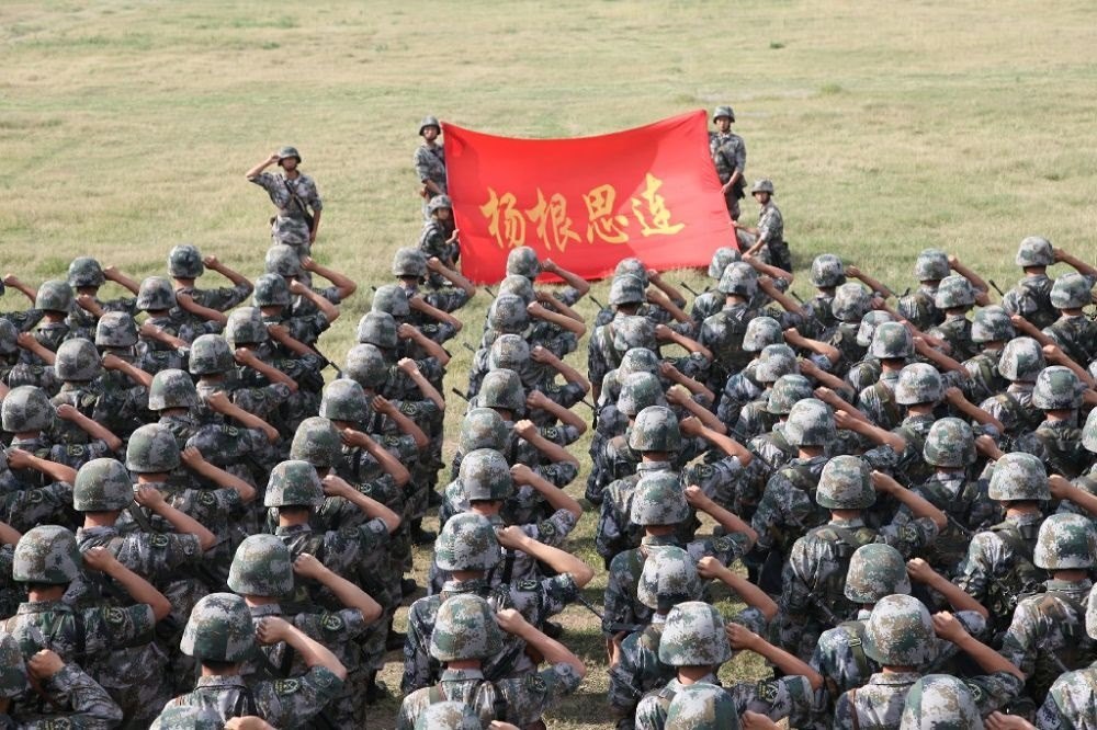 ↑“楊根思連”官兵執(zhí)行任務(wù)前向連旗宣誓（資料照片）。新華社發(fā)