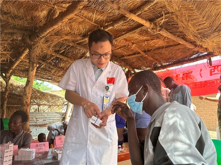 圖為南昌大學第一附屬醫(yī)院病理科主治醫(yī)師張振東為村民解說藥品使用方法。中國駐乍得醫(yī)療隊供圖