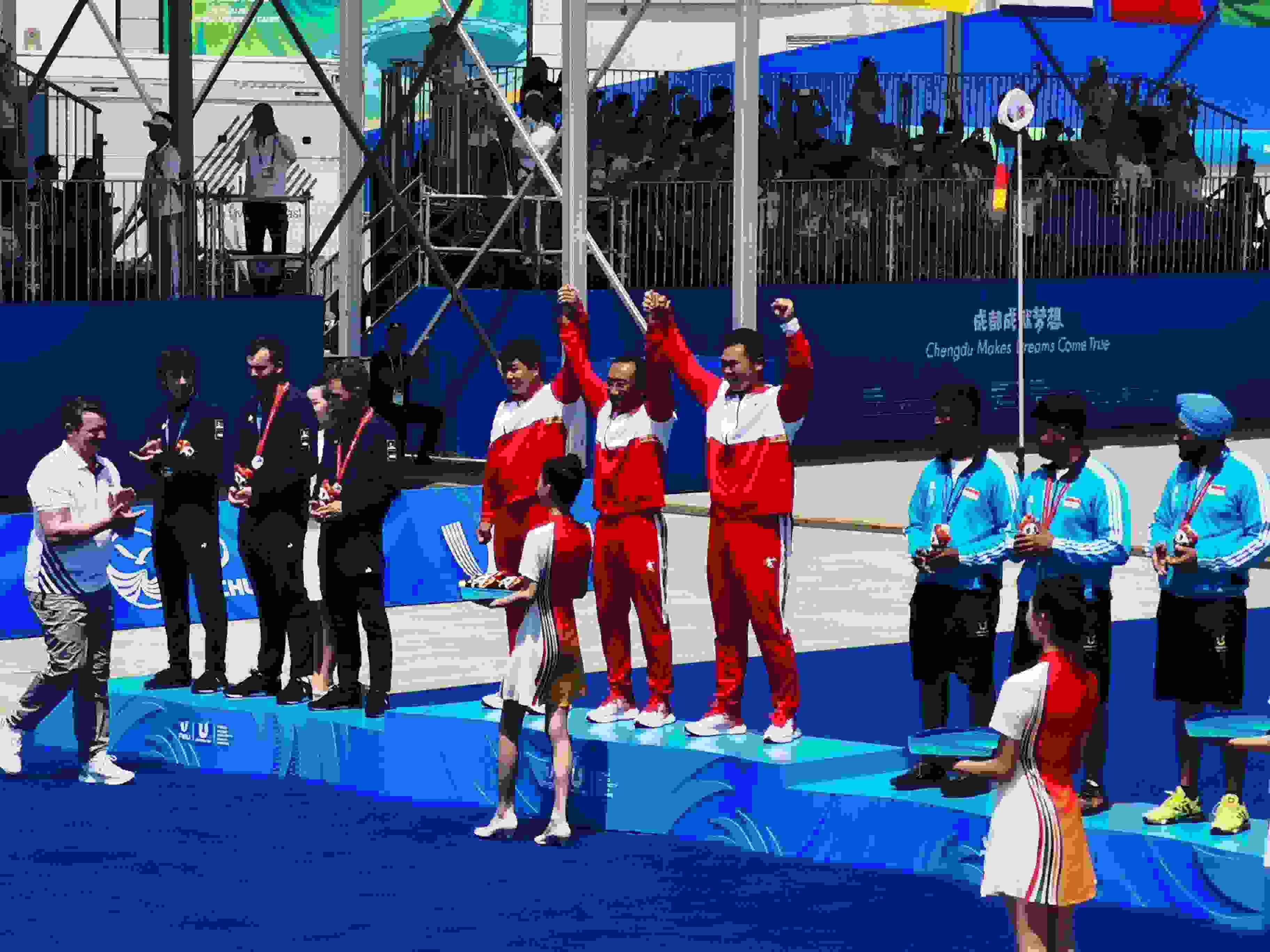 7月30日，在成都大運會男子復合弓團體頒獎儀式中，中國隊慶祝奪得冠軍。 人民網(wǎng)記者 楊磊攝