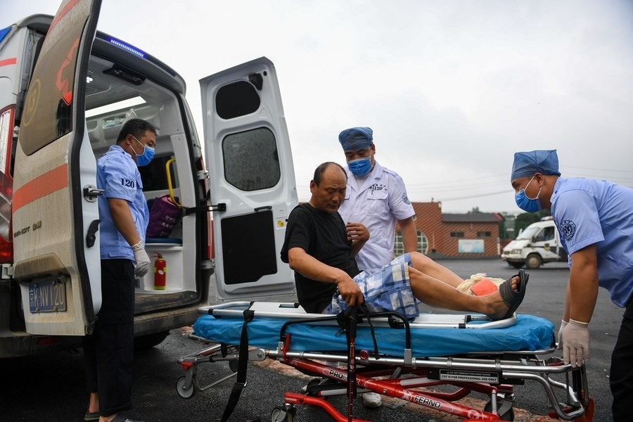 8月1日，在北京市門頭溝區(qū)妙峰山鎮(zhèn)妙峰山民族學(xué)校臨時(shí)安置點(diǎn)，北京急救中心工作人員在轉(zhuǎn)運(yùn)一名受傷村民。新華社記者 鞠煥宗 攝