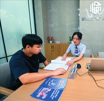 在杭州市臨安區(qū)政務(wù)服務(wù)中心的“為企服務(wù)中心”，黨員志愿者（右）解答企業(yè)主的疑問（2023年7月7日攝）。徐昱攝/本刊