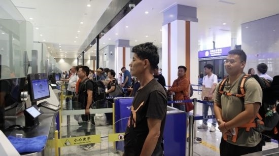 6月13日，乘坐中老鐵路國際旅客列車的旅客在磨憨邊檢大廳排隊(duì)候檢。李揚(yáng) 攝