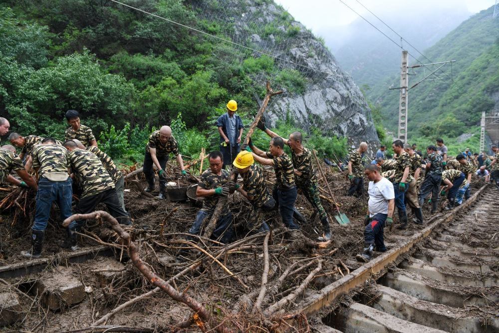 8月1日，在北京市門頭溝區(qū)水峪嘴村附近一段被阻斷的鐵路線上，中鐵六局工作人員在清理軌道上的雜物，全力恢復交通。新華社記者 鞠煥宗 攝