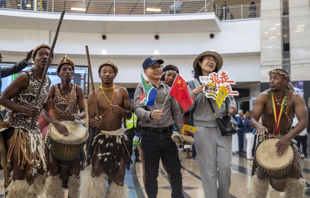 在南非約翰內(nèi)斯堡坦博國際機場，南非舞蹈演員歡迎中國試點恢復(fù)出境團隊旅游后首批抵達南非的中國游客（2023年3月29日攝）。