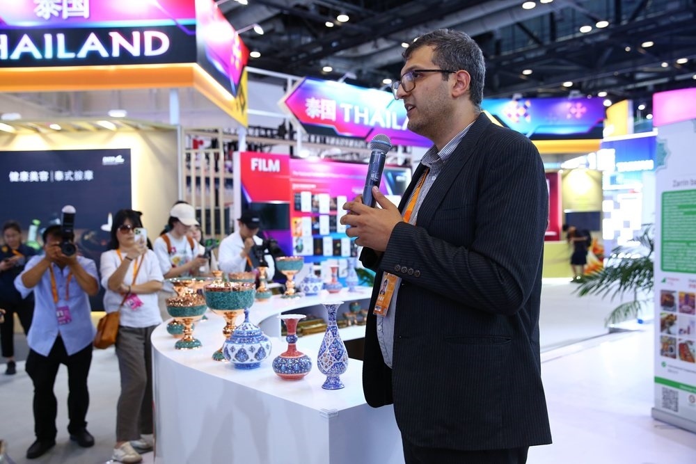 9月1日，參展商在國家會議中心向媒體記者介紹展臺信息。新華社記者 孫瑋彤 攝