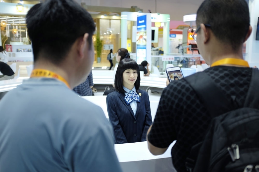 9月1日，媒體記者在國家會議中心與服務(wù)機器人互動。新華社記者 劉夢琪 攝