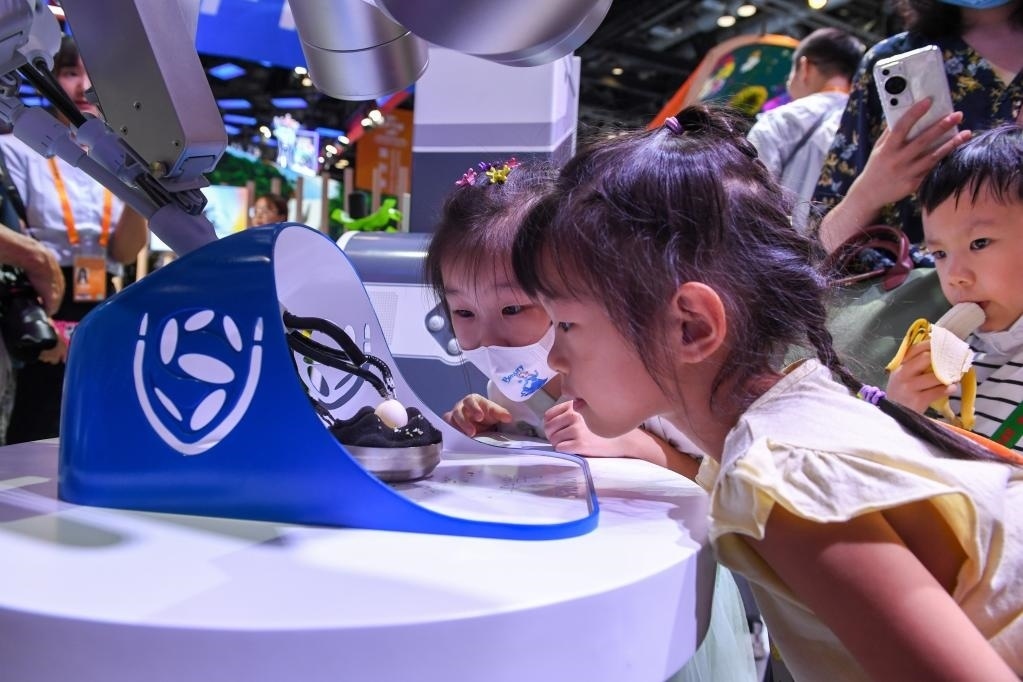 9月3日，幾名小朋友在國家會議中心觀看單孔腔鏡手術(shù)機器人展示。新華社記者 鞠煥宗 攝