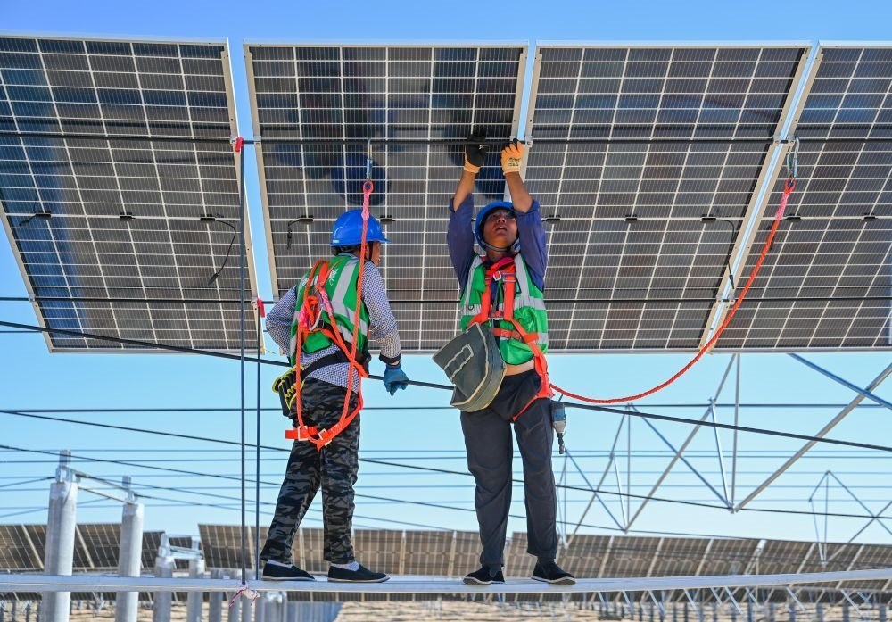 2023年7月22日，工人在位于內(nèi)蒙古杭錦旗庫布其沙漠億利生態(tài)示范區(qū)的蒙西基地庫布其200萬千瓦光伏治沙項目工地安裝光伏板。新華社記者 劉磊 攝
