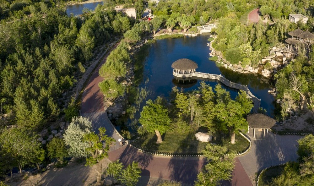 坐落在寧夏銀川市賀蘭山腳下的賀蘭山運動休閑公園（2021年5月27日攝，無人機照片）。這里曾是一片砂石采礦塌陷區(qū)，當(dāng)?shù)赝ㄟ^植被景觀再造、水系建設(shè)、現(xiàn)代管網(wǎng)鋪建等手段，重新利用廢石、廢坑及各類廢棄建筑材料，把這里變成一座免費開放的主題公園。新華社記者 馮開華 攝