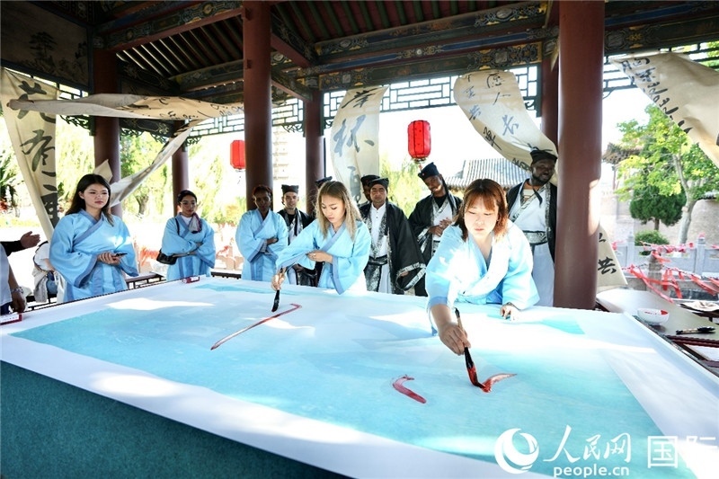 選手們提筆書寫“家園”二字。人民網(wǎng) 盧鵬宇攝