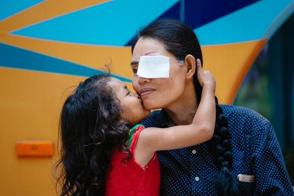 2019年3月15日，在柬埔寨磅湛省醫(yī)院，即將接受白內(nèi)障手術(shù)的患者孫美樂(lè)接受女兒的親吻祝福。在接受了中國(guó)醫(yī)療隊(duì)的白內(nèi)障義診手術(shù)后，她的視力逐步恢復(fù)，生活有了新的光明和希望。