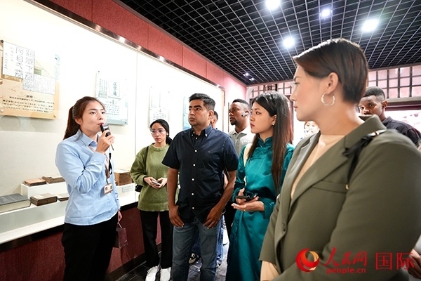 選手們認真聆聽導游講解。人民網(wǎng) 盧鵬宇攝