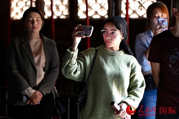 選手顏青（蘇丹）用手機記錄所見所感。人民網(wǎng) 盧鵬宇攝