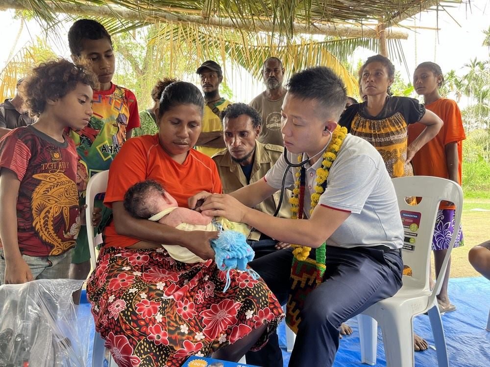 2023年8月5日，在巴布亞新幾內(nèi)亞中央省的一個(gè)村莊里，第12批援巴新中國醫(yī)療隊(duì)副隊(duì)長、新生兒科副主任醫(yī)師劉振球?yàn)楫?dāng)?shù)貗雰郝犜\檢查。新華社發(fā)（第12批援巴新中國醫(yī)療隊(duì)供圖）