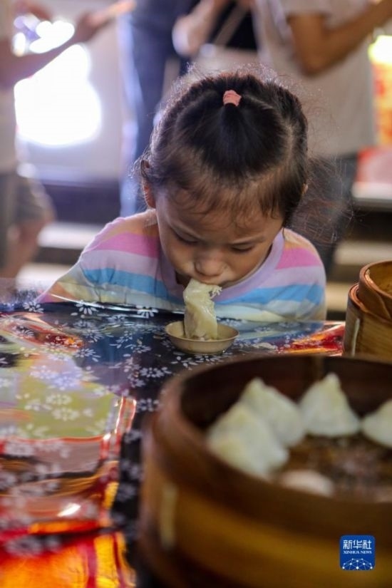 9月27日，小朋友在南翔小籠長(zhǎng)街宴上品嘗南翔小籠。