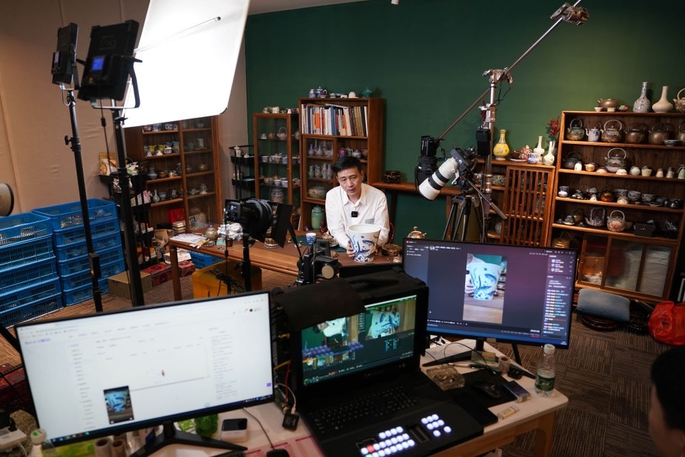 ↑在景德鎮(zhèn)，工作人員通過(guò)網(wǎng)絡(luò)直播推介陶瓷產(chǎn)品（2023年2月22日攝）。