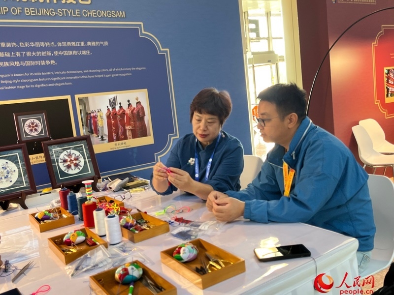 記者在新聞中心非遺傳承人展區(qū)進行體驗。人民網(wǎng)記者 杜燕飛攝