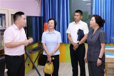 圖③：“小公民法律課堂”開講前，全國人大代表殷其龍（右二）、重慶市人大代表李自玲（左二）聽取楊家坪中學負責人關于未成年人思想教育工作情況的介紹。