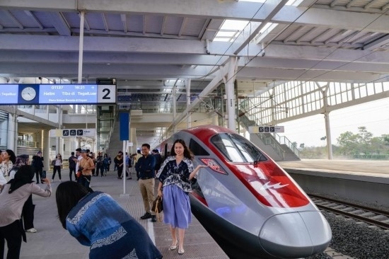  10月17日，在印度尼西亞萬隆德卡魯爾站，乘客在站臺上和雅萬高鐵高速動車組列車合影。新華社記者 徐欽 攝