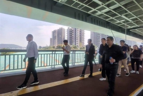 10月24日，2023“一帶一路”媒體合作論壇聯(lián)合采訪團(tuán)團(tuán)員走在清水塘大橋景觀通道上。本報(bào)記者 常雯宜攝