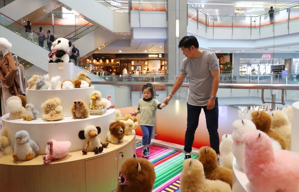 2023年11月2日，顧客在溫暖駝品牌專柜內(nèi)選購。連續(xù)六年參加進(jìn)博會的秘魯羊駝制品品牌溫暖駝在上海市中心商場開設(shè)了專柜。新華社記者 方喆 攝