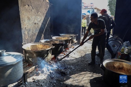 11月3日，在加沙地帶南部城市拉法，人們?cè)诿簹庵袛嗪笥貌窕鹱鲲?。新華社發(fā)（里澤克·阿卜杜勒賈瓦德攝）