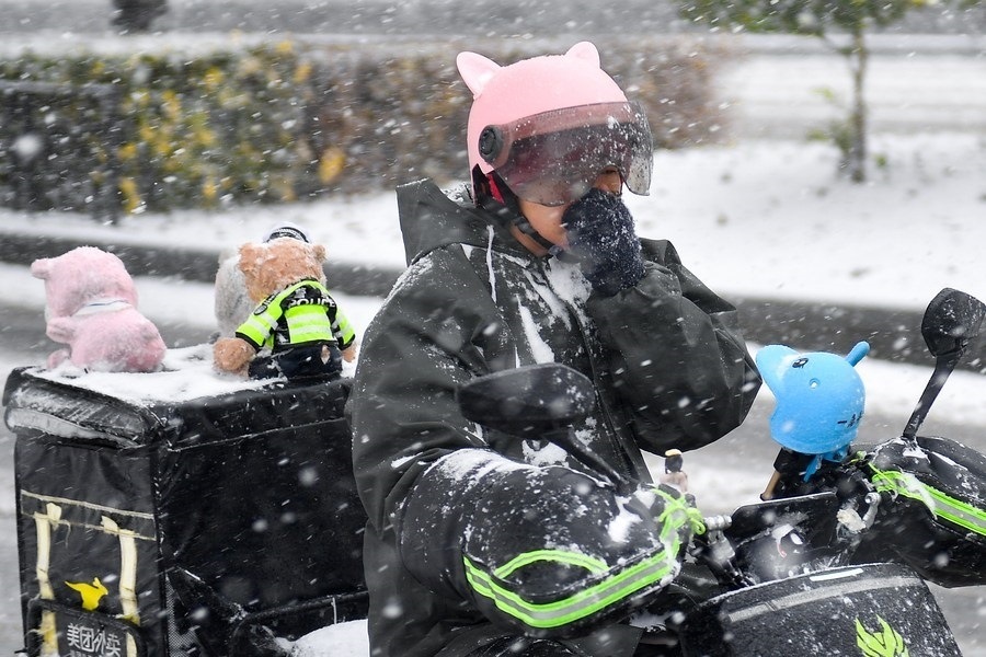 11月6日，在長春市街頭，一名外賣員在雪中騎行。新華社記者 許暢 攝