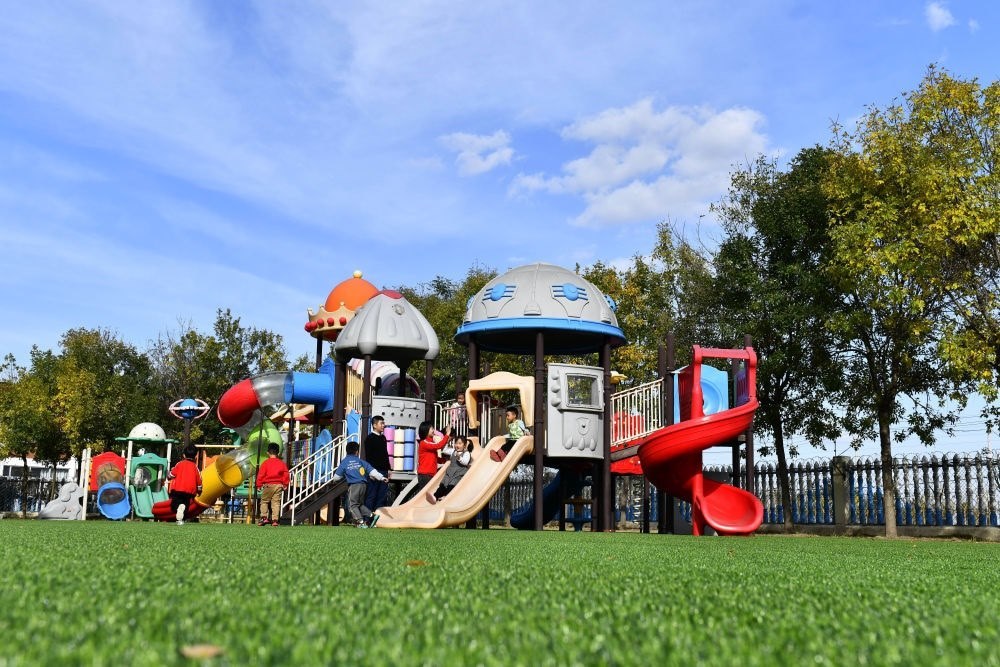 在山東省東營市墾利區(qū)楊廟社區(qū)幼兒園，孩子們在老師的帶領下進行戶外活動（2021年10月19日攝）。新華社記者 郭緒雷 攝