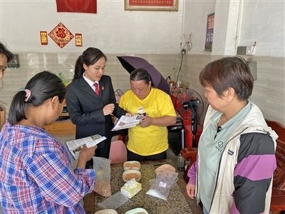  圖⑤：龍圩區(qū)法院法官到群眾家中開展法治宣傳。資料圖片