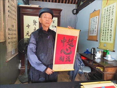 越南首都河內(nèi)文廟內(nèi)，阮明珠展示“中越心相近”書法作品。
