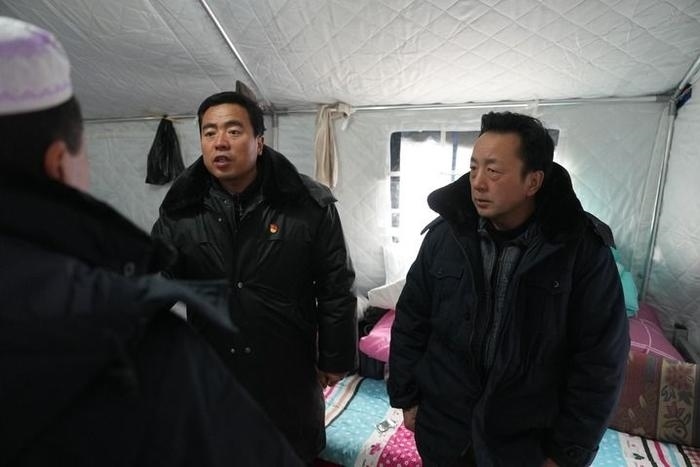 2023年12月22日，積石山縣大河家鎮(zhèn)大河村黨支部書記馬成忠（右二）在帳篷里和受災(zāi)群眾交流。新華社記者 陳斌 攝