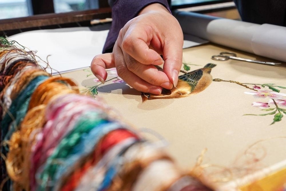 △2023年7月6日，盧建英在江蘇蘇州平江路的工作室內(nèi)刺繡。