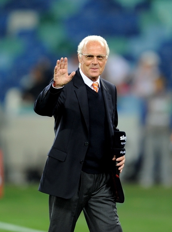 這是2010年7月7日，在南非德班舉行的2010年足球世界杯德國隊對陣西班牙隊的半決賽前，貝肯鮑爾接受電視臺采訪時和友人打招呼。新華社記者 王毓國 攝