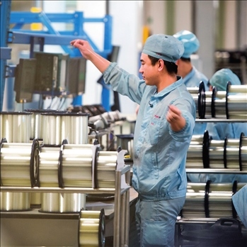 在位于武漢的長(zhǎng)飛光纖光纜股份有限公司光纖生產(chǎn)車間內(nèi)，工作人員對(duì)光纖進(jìn)行檢測(cè)（資料圖片）。肖藝九攝/本刊