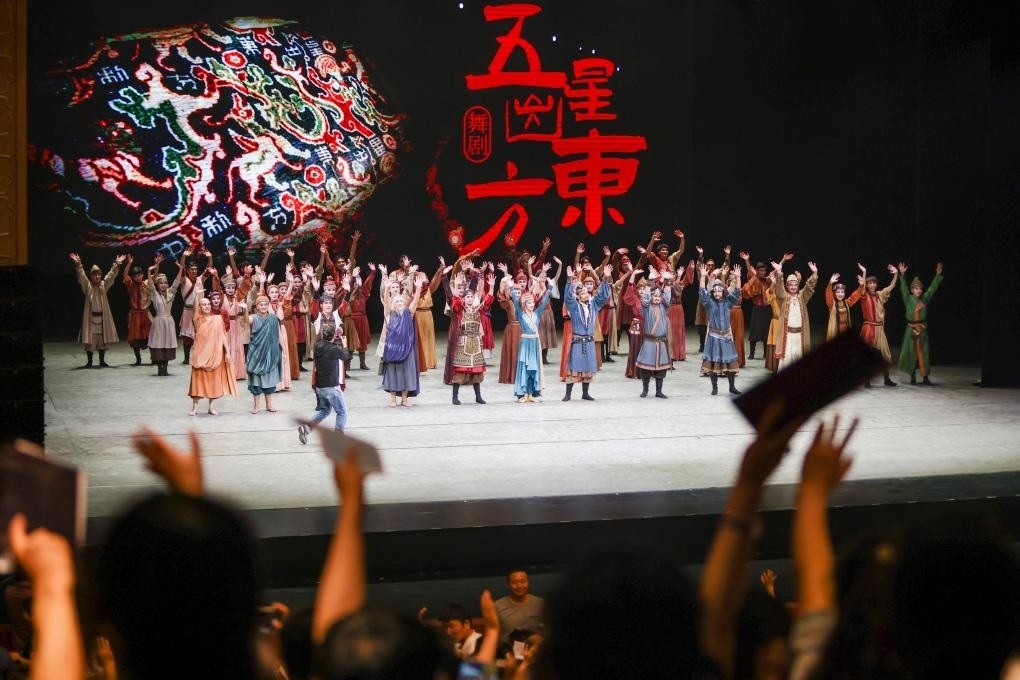2023年7月31日，新疆和田地區(qū)新玉歌舞團(tuán)在烏魯木齊京劇院演出舞劇《五星出東方》后和觀眾互相揮手致意。這場(chǎng)演出是第六屆中國(guó)新疆國(guó)際民族舞蹈節(jié)的參演劇目之一，曾榮獲國(guó)家“文華獎(jiǎng)”等。新華社記者 郝昭 攝