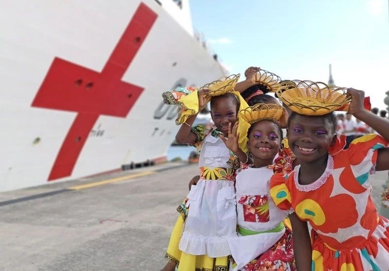 2018年10月，在安提瓜和巴布達首都圣約翰，當?shù)匦∨笥焉泶﹤鹘y(tǒng)服裝歡迎中國海軍“和平方舟”醫(yī)院船首次到訪。
