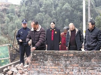  圖③：庭審結(jié)束后，在法官的見證下，陳某在院壩邊重新開鑿一條通道。