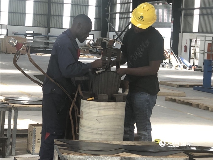 經(jīng)貿(mào)合作區(qū)廠房內(nèi)，當(dāng)?shù)毓と苏诰o張作業(yè)。人民網(wǎng)記者 黃培昭攝