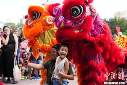 圖為舞獅表演吸引民眾合影。張興龍攝