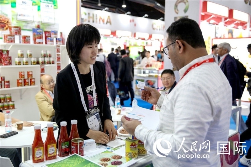 圖為中國參展企業(yè)代表與采購商交流。人民網(wǎng) 塔里克·易卜拉欣攝