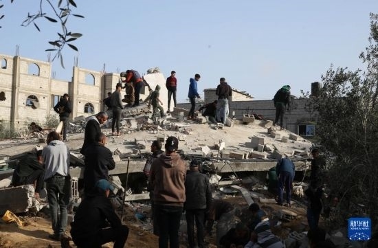  3月3日，在加沙地帶南部城市拉法，人們查看被以軍空襲破壞的建筑。新華社發(fā)（哈立德·奧馬爾攝）